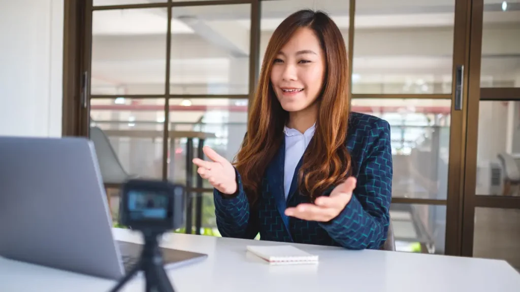 Seorang kandidat wanita Indonesia sedang melakukan online interview kerja menggunakan Bahasa Inggris dengan penuh percaya diri dan gestur tubuh yang profesional dari rumah.